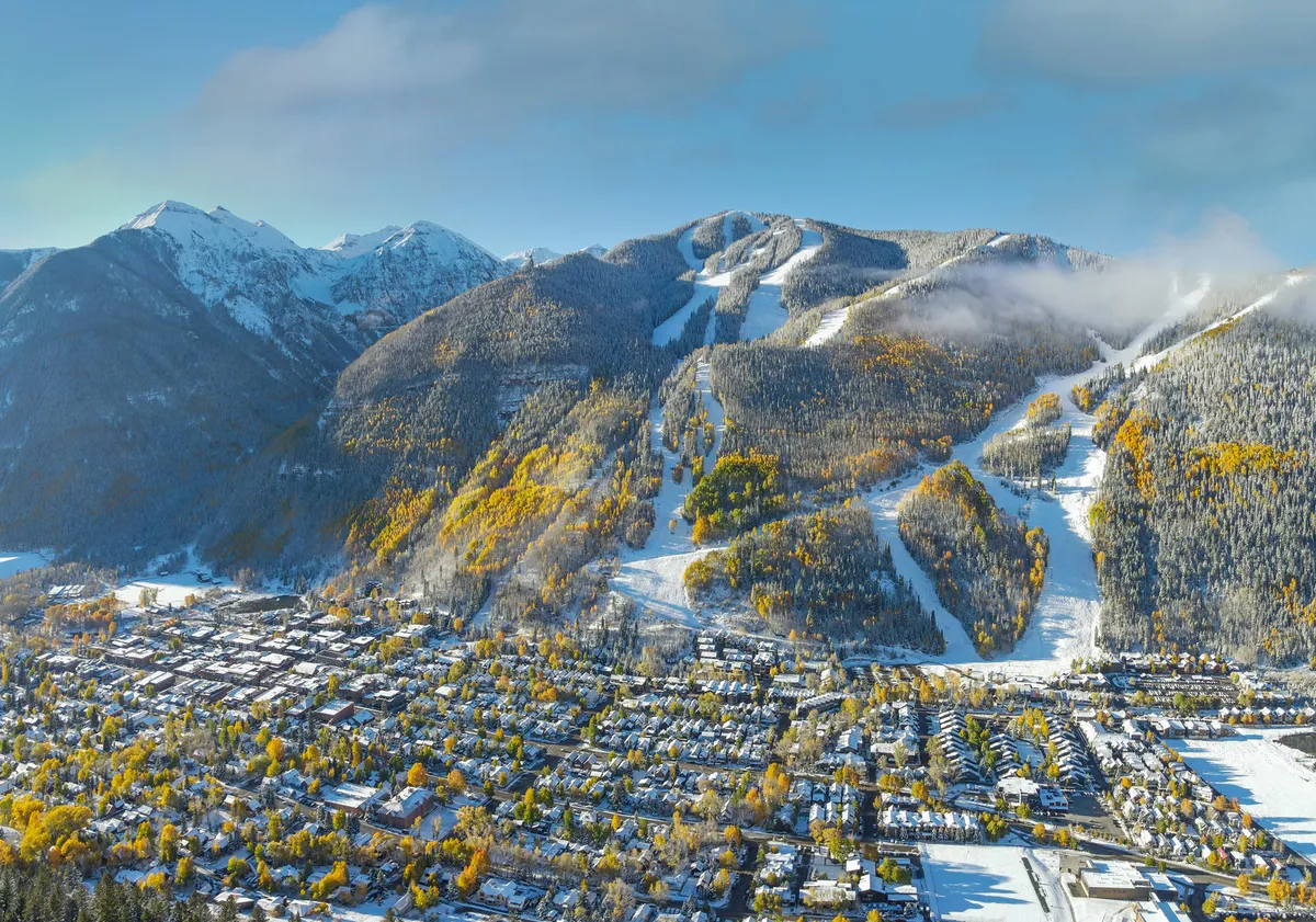 This view image captures snow-covered mountains, ski slopes, colorful autumn trees, and the vibrant town below—a breathtaking vantage point that immerses viewers in Telluride’s natural beauty and adventure.